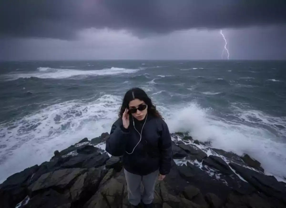 A person wearing sunglasses stands on rocky terrain by the stormy ocean as a huge tentacled sea creature rises from the turbulent water under dark storm clouds with lightning, depicted in a hyperrealistic style suitable for AI video generator and cinematic AI video projects.