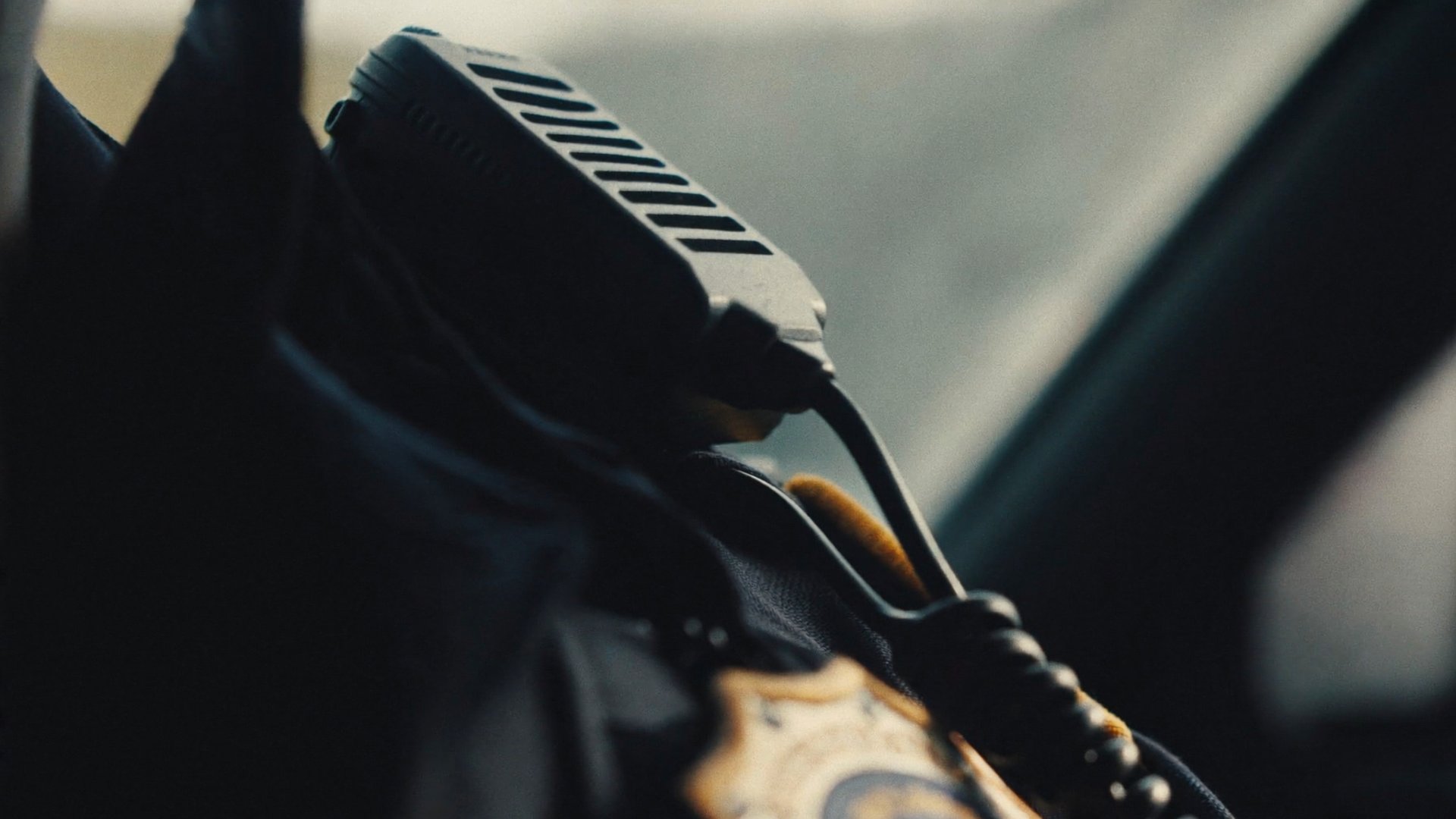Extreme close-up of a handheld radio mic clipped to a dark police uniform