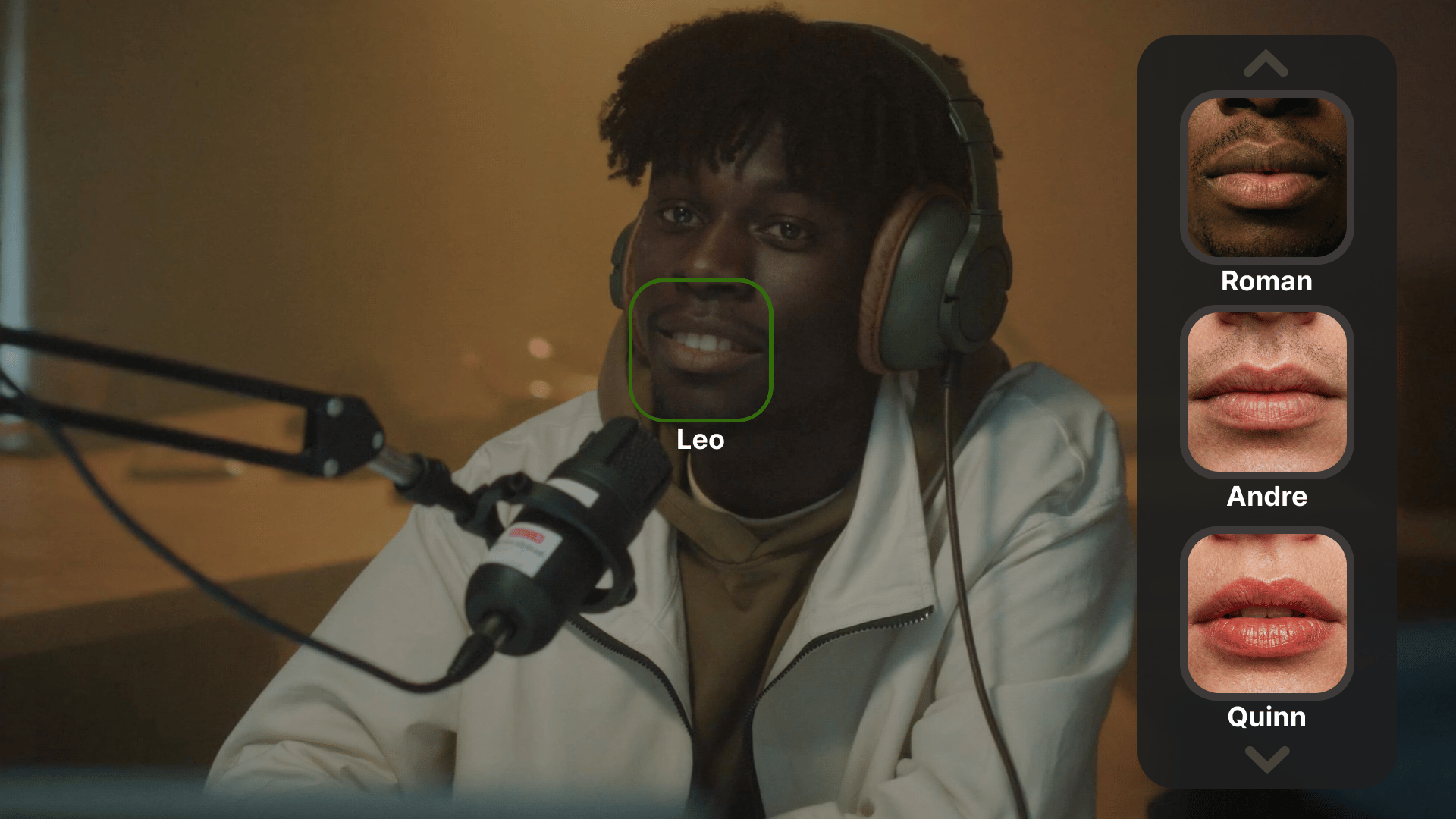 A cinematic, medium shot of a young Black man with curly hair wearing large over-ear headphones and a cream-colored zip-up hoodie. He is sitting in a dimly lit, warm-toned studio recording a podcast, with a professional XLR microphone on a boom arm in the foreground. Overlaid on the right side of the frame is a sleek, dark translucent mobile UI vertical menu featuring three close-up thumbnail options of different people's lips (labeled "Roman", "Andre", and "Quinn"). On the man's face, a soft green glowing square tracks his mouth, labeled "Leo" underneath. High-end photography, shallow depth of field, tech-noir aesthetic.