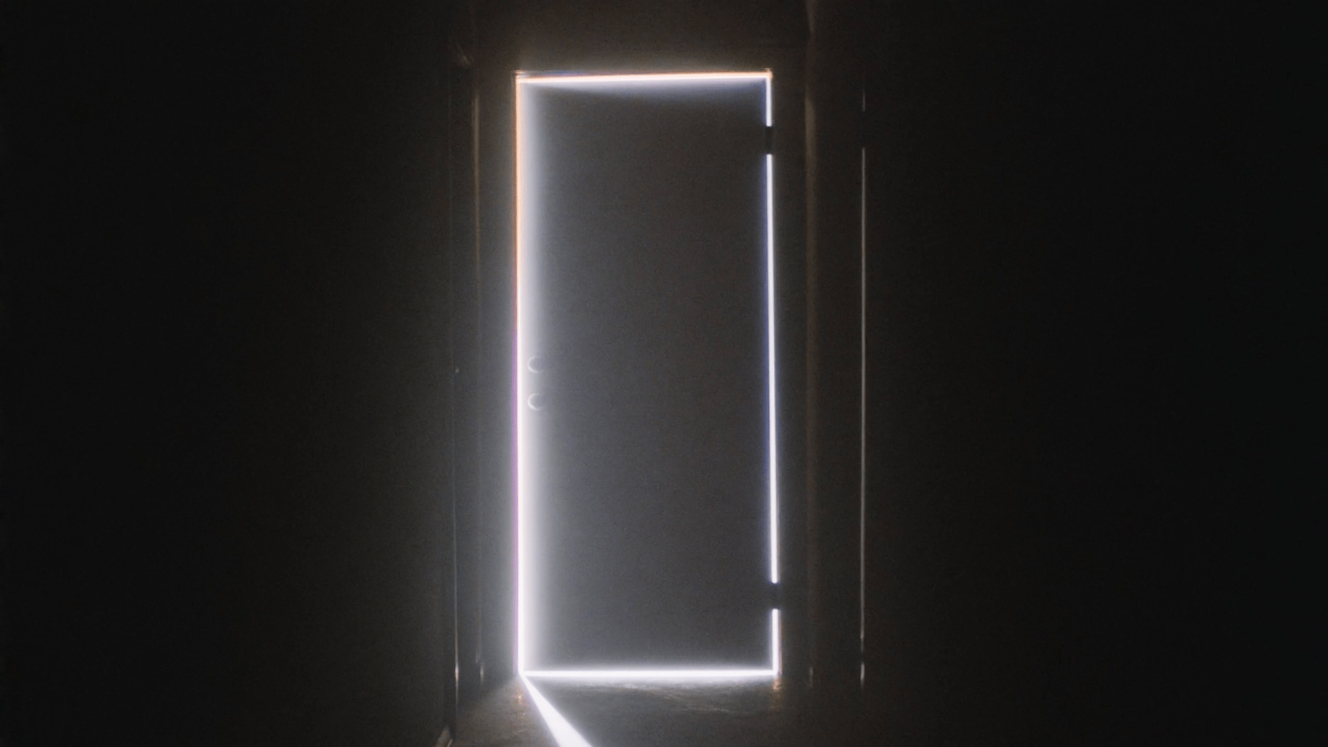 A dark interior hallway with a single closed door at the end of the corridor.
