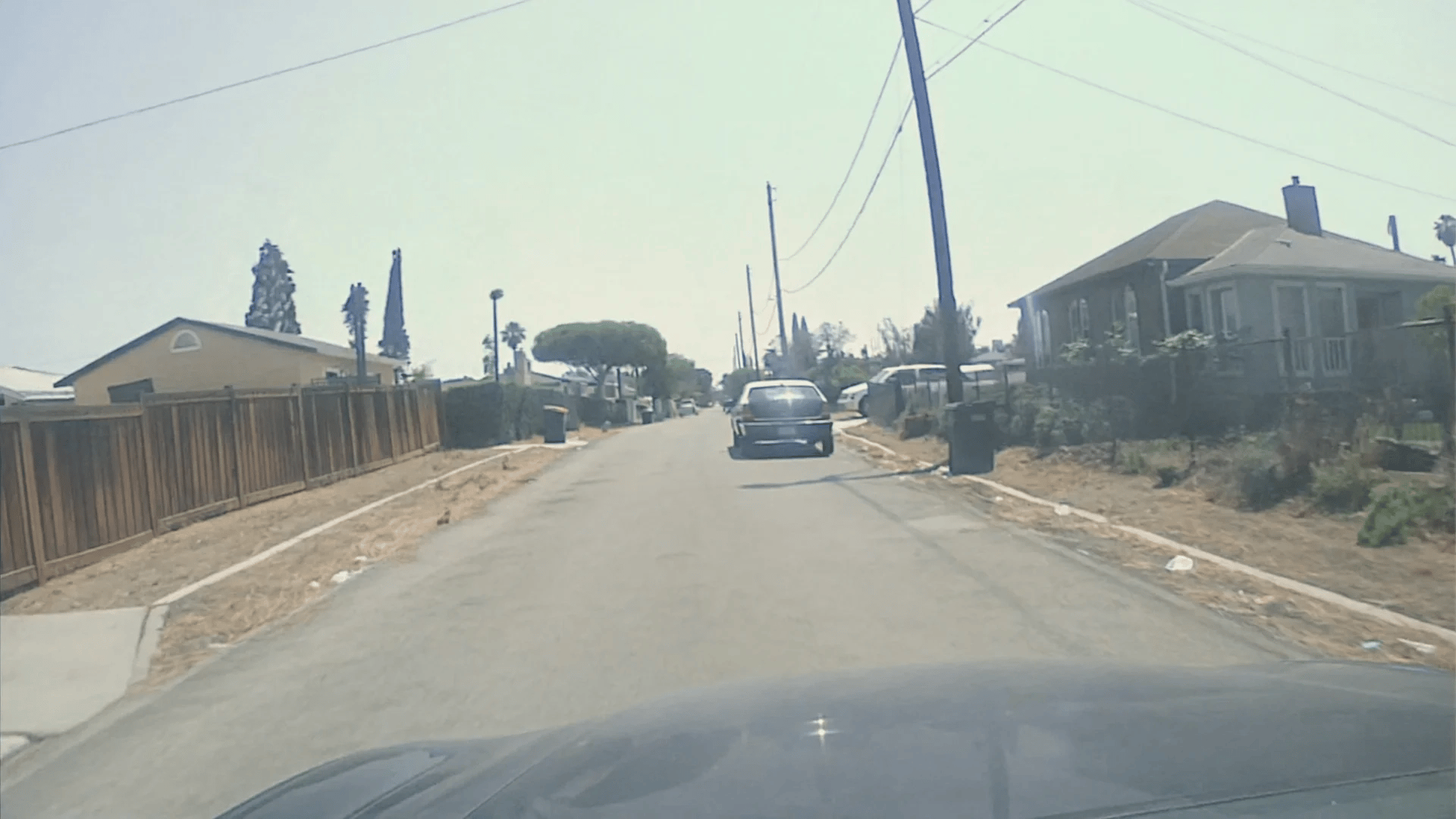 Dash-mounted police cruiser DVR perspective, hood of the patrol car visible at the bottom